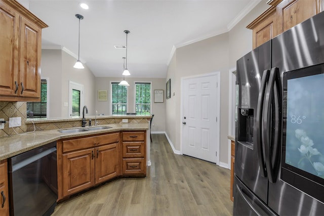 18024 Cindy Ln, Conroe, TX 77302 - kitchen featuring stainless steel fridge with ice dispenser, dishwashing machine, a sink, brown cabinets, and a peninsula