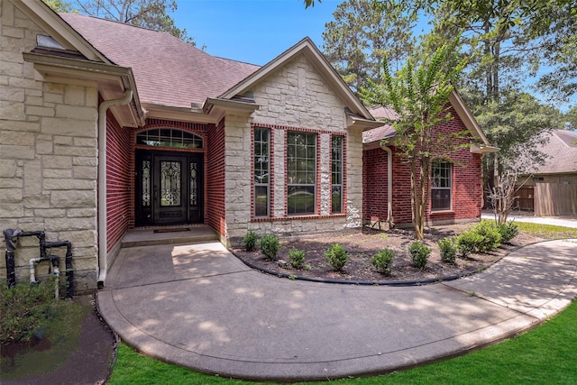 18024 Cindy Ln, Conroe, TX 77302 - doorway to property with stone siding and roof with shingles