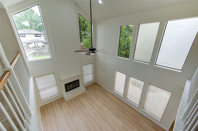 1715 Cobblestone Ct, Richmond, TX 77406 - unfurnished living room featuring light wood-type flooring, high vaulted ceiling, a ceiling fan, a large fireplace, and recessed lighting