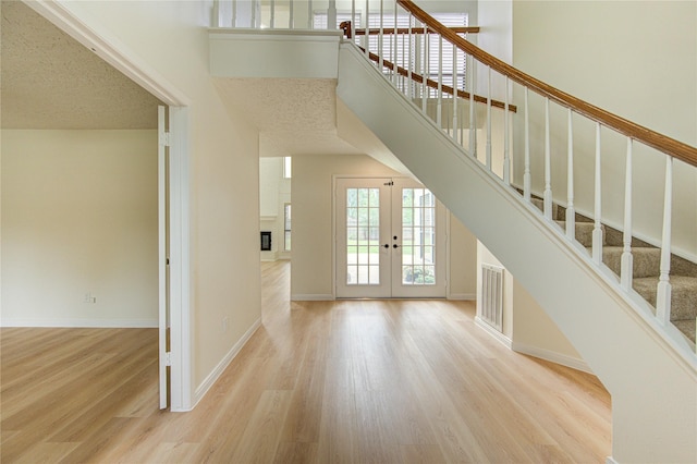 1715 Cobblestone Ct, Richmond, TX 77406 - unfurnished living room with wood finished floors, french doors, stairway, baseboards, and a high ceiling