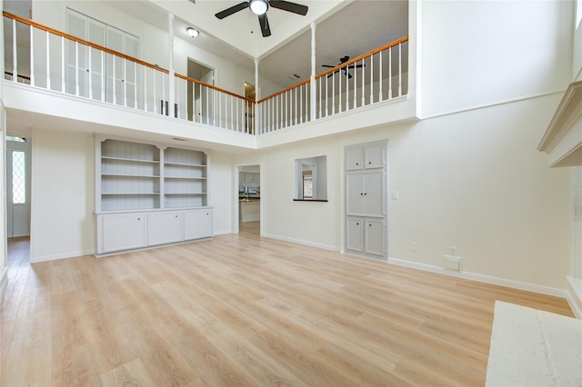 1715 Cobblestone Ct, Richmond, TX 77406 - unfurnished living room featuring a towering ceiling, ceiling fan, light wood-style flooring, and baseboards