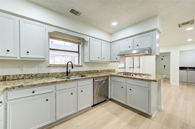 1715 Cobblestone Ct, Richmond, TX 77406 - kitchen with appliances with stainless steel finishes, a sink, under cabinet range hood, light wood-style flooring, and recessed lighting
