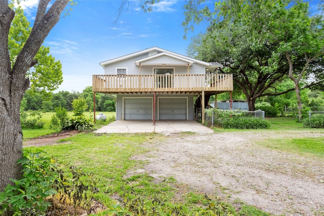 3225 N Jackson St, Santa Fe, TX 77517 - view of front of house with dirt driveway, a wooden deck, a garage, and a front lawn