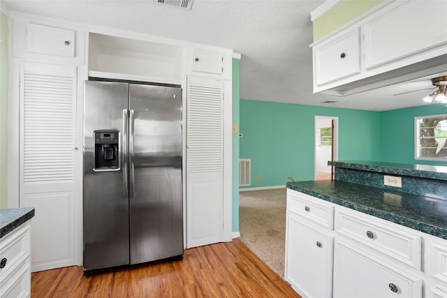 3225 N Jackson St, Santa Fe, TX 77517 - kitchen featuring stainless steel fridge with ice dispenser, dark countertops, and white cabinets