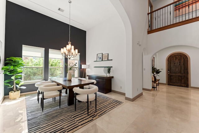82 Valera Ridge Dr, Spring, TX 77389 - dining area with arched walkways, a high ceiling, baseboards, a chandelier, and light tile patterned floors
