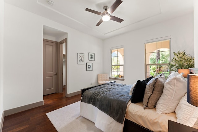 82 Valera Ridge Dr, Spring, TX 77389 - bedroom with dark wood-style floors, baseboards, a ceiling fan, and a raised ceiling