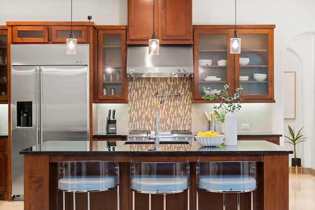 82 Valera Ridge Dr, Spring, TX 77389 - kitchen with stainless steel built in refrigerator, wall chimney range hood, decorative backsplash, decorative light fixtures, and a sink