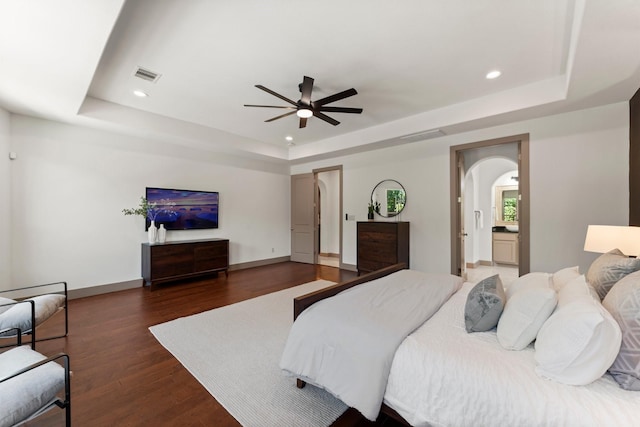 82 Valera Ridge Dr, Spring, TX 77389 - bedroom featuring a raised ceiling, arched walkways, recessed lighting, wood finished floors, and baseboards