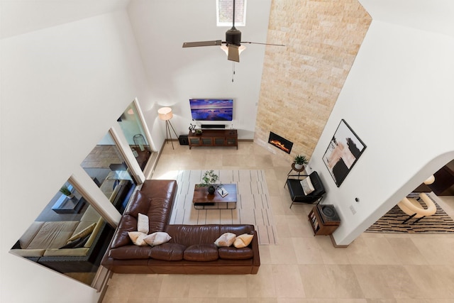 82 Valera Ridge Dr, Spring, TX 77389 - tiled living area featuring a large fireplace, ceiling fan, and a high ceiling