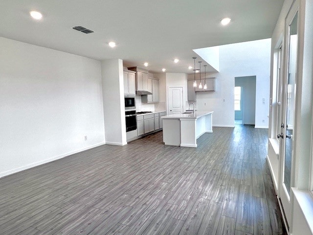 21910 Wycombe Terrace Way, Cypress, TX 77433 - kitchen featuring open floor plan, built in microwave, oven, dark wood-type flooring, and a kitchen island with sink