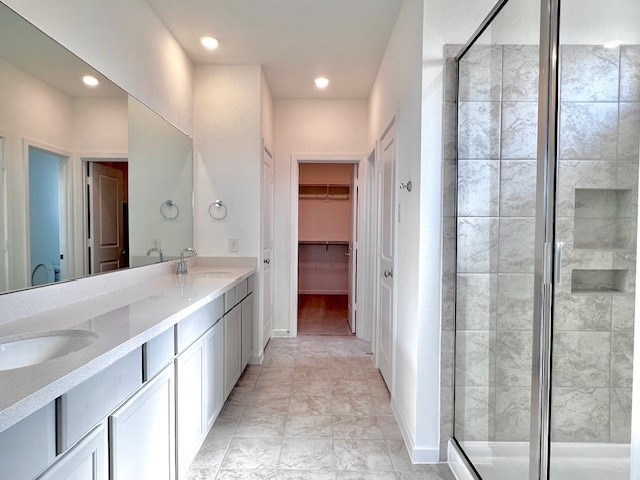 21910 Wycombe Terrace Way, Cypress, TX 77433 - full bath featuring a shower stall, double vanity, recessed lighting, and a walk in closet
