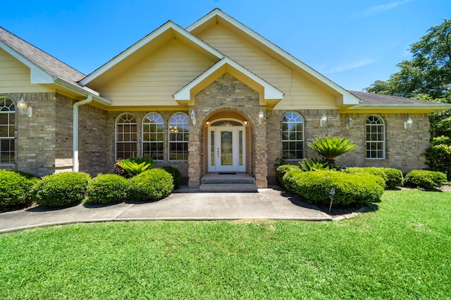189 Northwood Park, Livingston, TX 77351 - doorway to property featuring a lawn and brick siding
