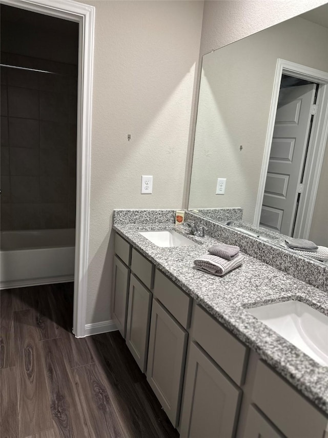 13556 Bowfin Dr, Conroe, TX 77384 - bathroom with double vanity, wood finished floors, shower / bathtub combination, and baseboards