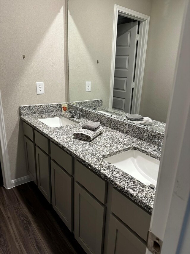 13556 Bowfin Dr, Conroe, TX 77384 - bathroom with double vanity, wood finished floors, and baseboards