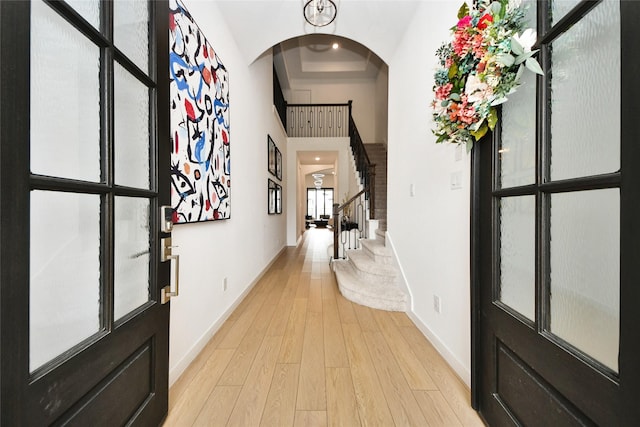 23619 Bottlebrush Terrace Trl, Katy, TX 77493 - foyer with arched walkways, baseboards, light wood-style flooring, stairway, and a high ceiling