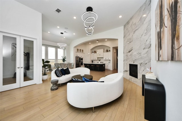 23619 Bottlebrush Terrace Trl, Katy, TX 77493 - living room featuring recessed lighting, light wood-type flooring, french doors, and a fireplace