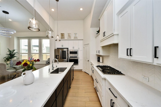23619 Bottlebrush Terrace Trl, Katy, TX 77493 - kitchen with appliances with stainless steel finishes, a sink, tasteful backsplash, pendant lighting, and white cabinets
