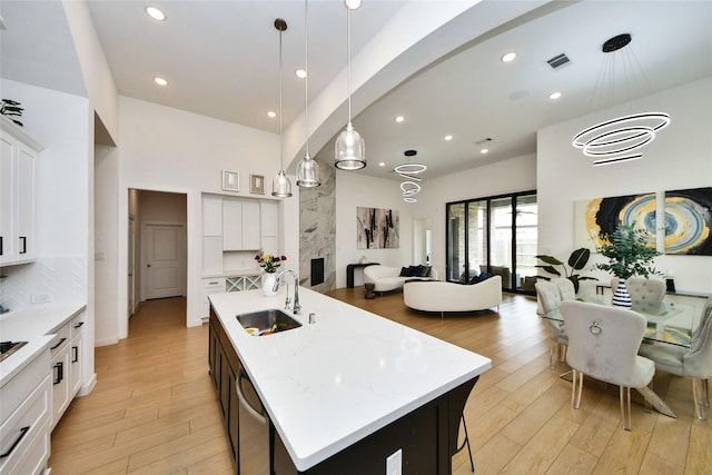 23619 Bottlebrush Terrace Trl, Katy, TX 77493 - kitchen featuring a sink, light wood finished floors, an island with sink, white cabinets, and recessed lighting