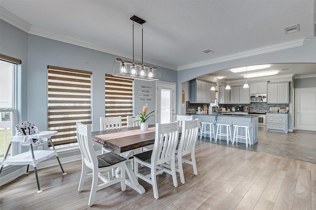 2774 Gulfview Ln, Crystal Beach, TX 77650 - dining space with crown molding, healthy amount of natural light, light wood-style flooring, and arched walkways