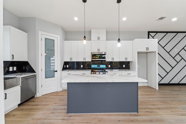 6631 Foster St, Houston, TX 77021 - kitchen featuring appliances with stainless steel finishes, decorative backsplash, light wood-type flooring, white cabinetry, and recessed lighting