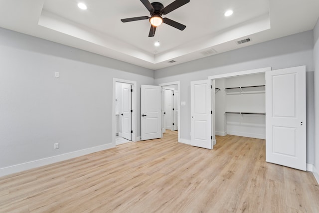 6631 Foster St, Houston, TX 77021 - unfurnished bedroom featuring a tray ceiling, baseboards, light wood-type flooring, recessed lighting, and a walk in closet