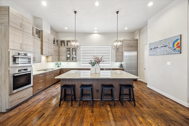 2707 Rusk St, Houston, TX 77003 - kitchen with stainless steel appliances, a center island, a chandelier, a kitchen breakfast bar, and dark wood-type flooring