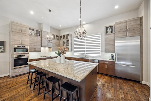 2707 Rusk St, Houston, TX 77003 - kitchen featuring stainless steel appliances, a chandelier, a center island, a breakfast bar area, and decorative backsplash
