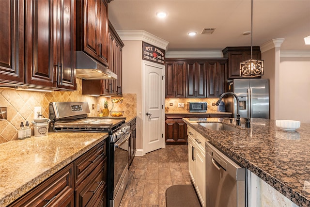 2323 Foley Rd, Crosby, TX 77532 - kitchen featuring appliances with stainless steel finishes, under cabinet range hood, ornamental molding, decorative light fixtures, and backsplash
