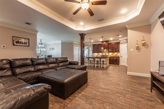 2323 Foley Rd, Crosby, TX 77532 - living room featuring a raised ceiling, ceiling fan, crown molding, ornate columns, and recessed lighting