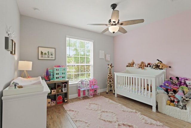 1603 Country Club Dr, Crosby, TX 77532 - bedroom featuring wood finished floors, a crib, ceiling fan, and baseboards