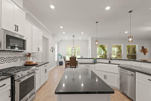 1603 Country Club Dr, Crosby, TX 77532 - kitchen with stainless steel appliances, a sink, a center island, tasteful backsplash, and white cabinets