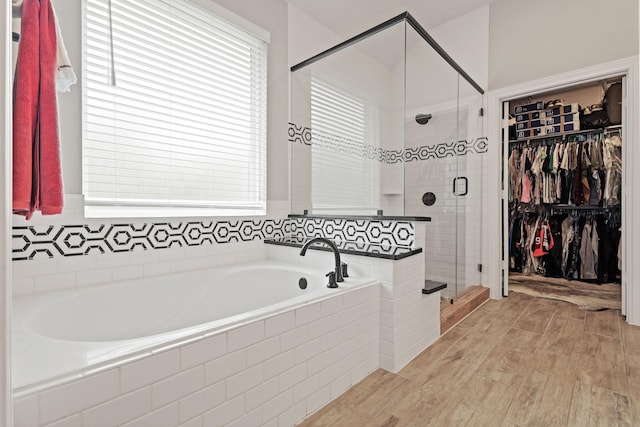 1603 Country Club Dr, Crosby, TX 77532 - bathroom with a garden tub, a shower stall, a walk in closet, and wood finished floors