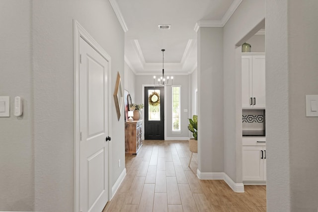 1603 Country Club Dr, Crosby, TX 77532 - foyer with ornamental molding, a raised ceiling, baseboards, light wood-type flooring, and a chandelier