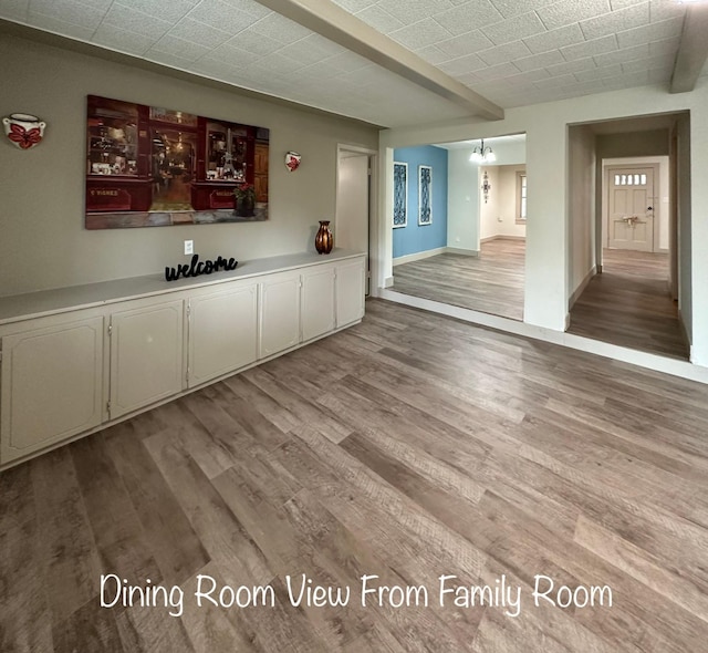 1602 W Blum St, Alvin, TX 77511 - unfurnished living room featuring wood finished floors and baseboards