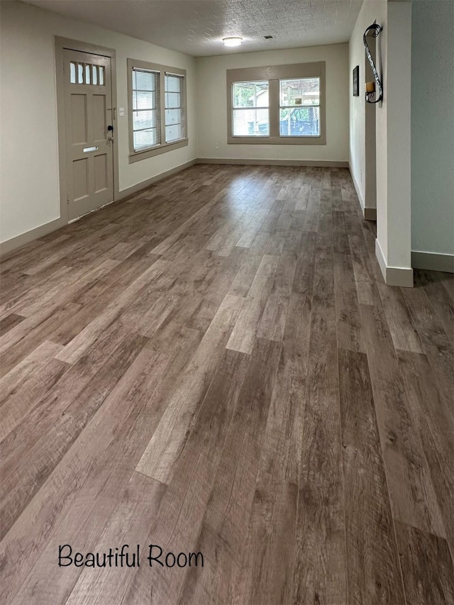 1602 W Blum St, Alvin, TX 77511 - unfurnished living room featuring wood finished floors and baseboards
