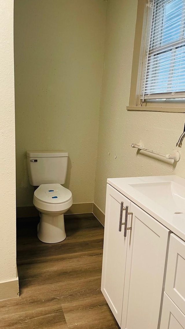 1602 W Blum St, Alvin, TX 77511 - half bath featuring toilet, wood finished floors, vanity, and baseboards