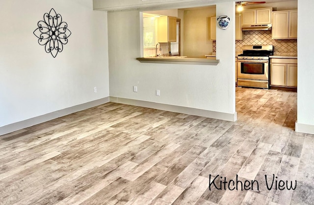 1602 W Blum St, Alvin, TX 77511 - kitchen featuring gas stove, light wood finished floors, backsplash, and under cabinet range hood