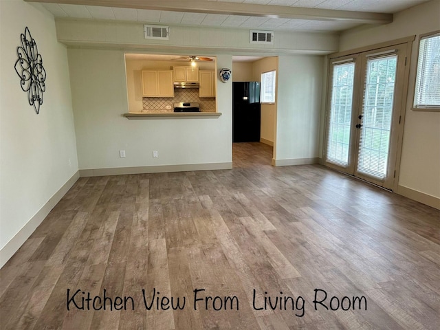 1602 W Blum St, Alvin, TX 77511 - unfurnished living room featuring wood finished floors, beam ceiling, french doors, baseboards, and a ceiling fan