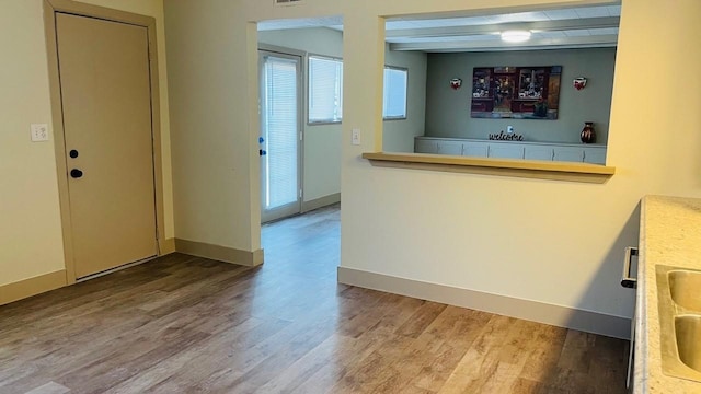 1602 W Blum St, Alvin, TX 77511 - kitchen featuring wood finished floors, baseboards, and light countertops
