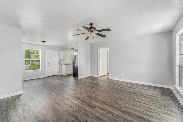 3517 Sparrow St, Houston, TX 77051 - unfurnished living room with dark wood-style floors, a textured ceiling, a ceiling fan, and baseboards