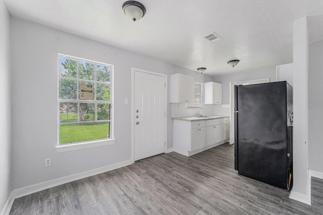 3517 Sparrow St, Houston, TX 77051 - kitchen with wood finished floors, light countertops, freestanding refrigerator, and white cabinetry