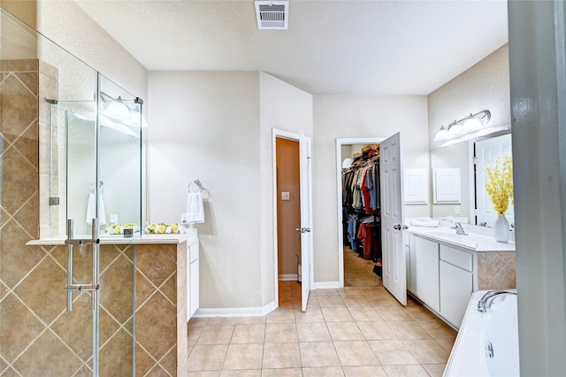 5838 Deleon Trail Dr, Spring, TX 77379 - full bathroom featuring a garden tub, vanity, tile patterned flooring, a walk in closet, and a tile shower