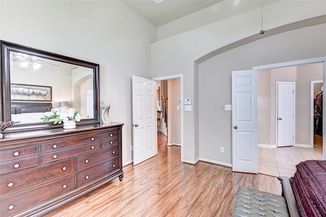 5838 Deleon Trail Dr, Spring, TX 77379 - bedroom featuring high vaulted ceiling, light wood-type flooring, baseboards, and arched walkways