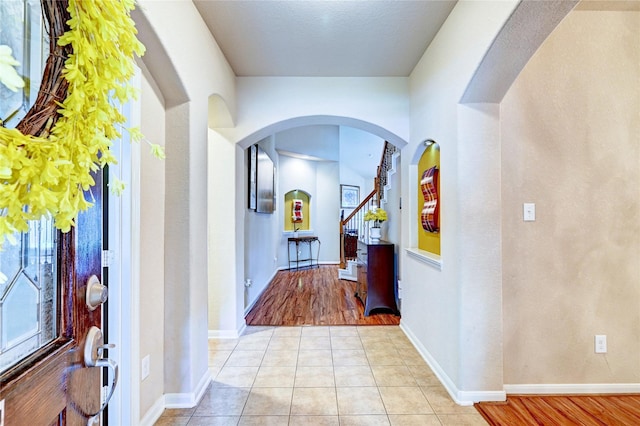 5838 Deleon Trail Dr, Spring, TX 77379 - foyer with arched walkways, baseboards, light tile patterned floors, and stairs