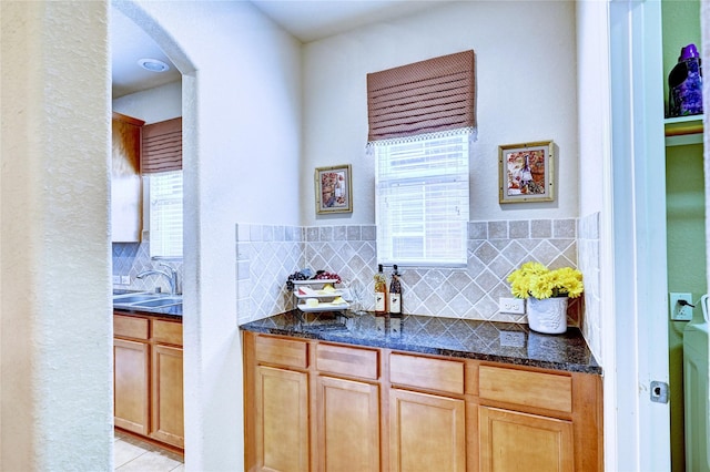 5838 Deleon Trail Dr, Spring, TX 77379 - bar area featuring arched walkways, tasteful backsplash, a sink, and light tile patterned flooring