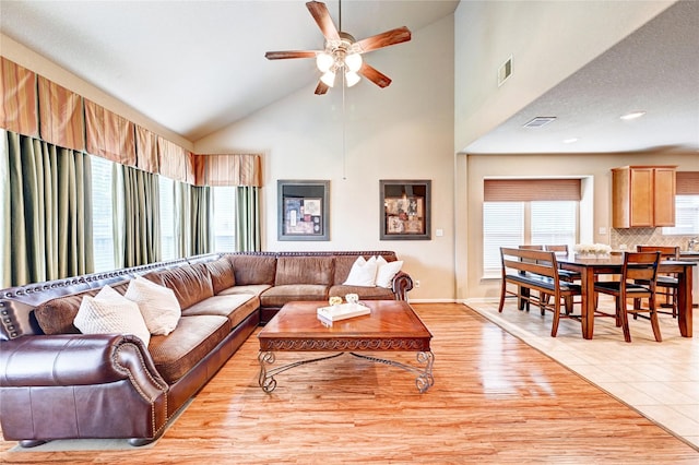 5838 Deleon Trail Dr, Spring, TX 77379 - living room with ceiling fan, high vaulted ceiling, light wood-style floors, and baseboards