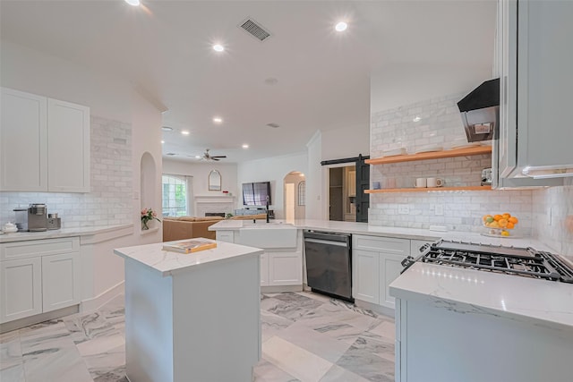 22 Tallow Hill Pl, Spring, TX 77382 - kitchen featuring dishwasher, arched walkways, a peninsula, ceiling fan, and open floor plan
