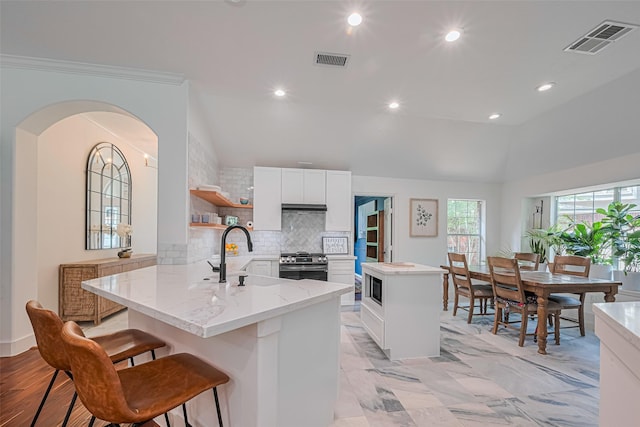 22 Tallow Hill Pl, Spring, TX 77382 - kitchen featuring gas range, built in microwave, a sink, vaulted ceiling, and a kitchen island