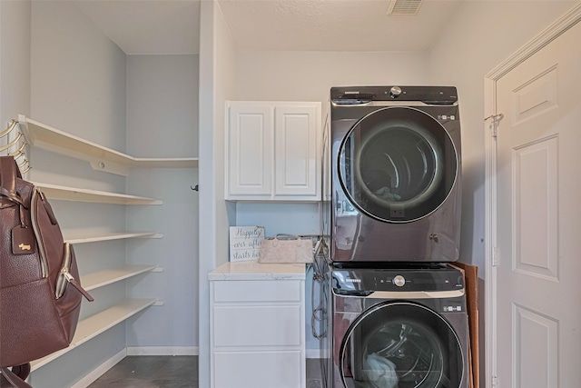 22 Tallow Hill Pl, Spring, TX 77382 - laundry area featuring stacked washing machine and dryer, cabinet space, and baseboards