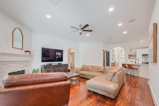 22 Tallow Hill Pl, Spring, TX 77382 - living area with arched walkways, wood finished floors, a ceiling fan, recessed lighting, and a fireplace